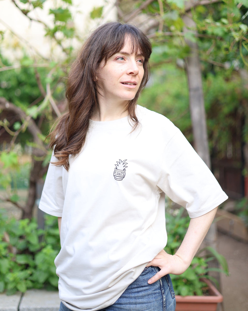 Woman wearing a white t-shirt with a pineapple graphic in an outdoor setting